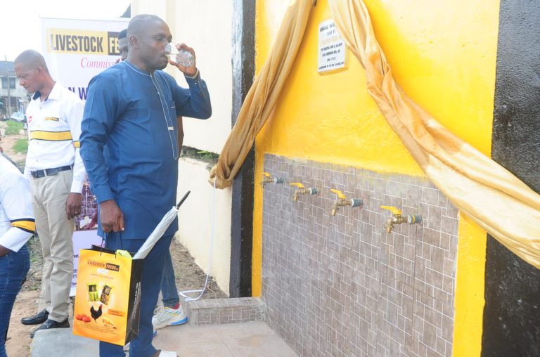 Community man drinking the water from the borehole at the event